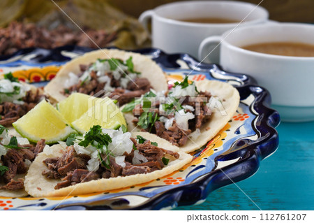 Mexican barbacoa beef tacos and beef barbacoa and barbacoa consommé 112761207
