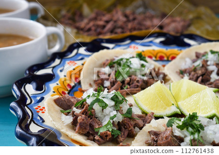 Mexican barbacoa beef tacos and beef barbacoa and barbacoa consommé 112761438