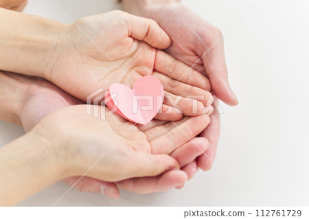 Hands of a man and a woman holding a heart-shaped object Hands of a man and a woman holding a heart-shaped object 112761729