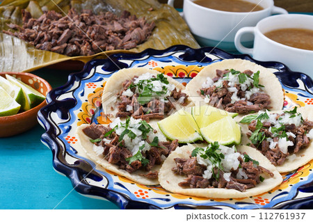Mexican barbacoa beef tacos and beef barbacoa and barbacoa consommé 112761937