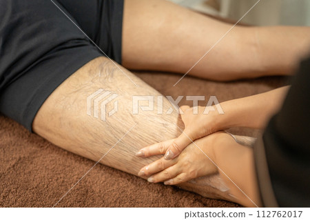 Esthetician and man massaging legs at men's beauty/hair removal salon Esthetician and man massaging legs at men's beauty/hair removal salon 112762017