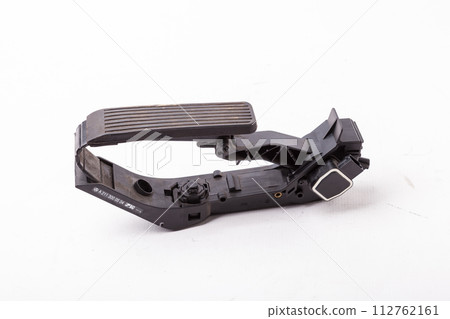 Gas pedal on a white isolated background in a photo studio for sale in a car service. Black auto part for replacement during repair in the workshop. Spare part junkyard. Gas pedal on a white isolated background in a photo studio for sale in a car service. Black auto part for replacement during repair in the workshop. Spare part junkyard. 112762161