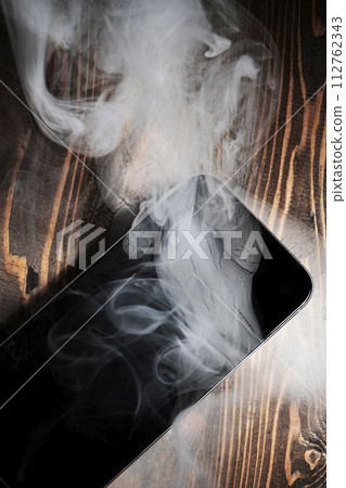 A broken mobile phone smoked A broken mobile phone smoked 112762343