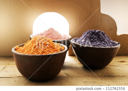 Close up of holi powder in wooden bowl on art decoration background with sunlight. Close up of holi powder in wooden bowl on art decoration background with sunlight. 112762358