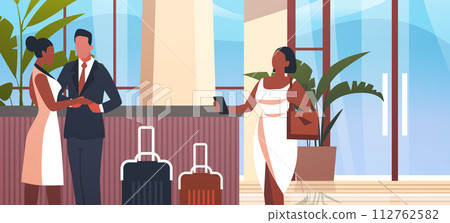 tourists with luggage departing from business trip standing at reception desk in hotel lobby recreation travel check-in concept 112762582