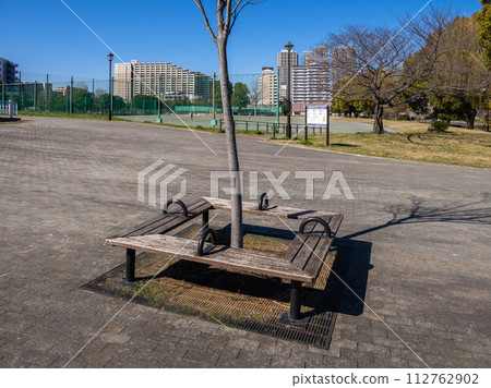 A bench with a partition placed on a slope in a park 112762902
