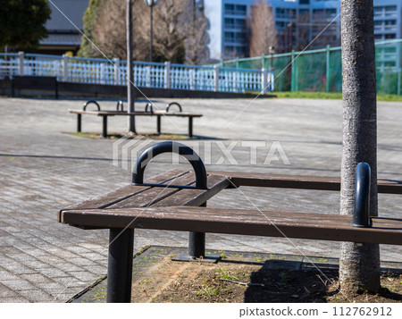 A bench with a partition placed on a slope in a park A bench with a partition placed on a slope in a park 112762912