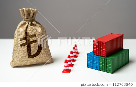 Shipping containers with goods and turkish lira money bag are separated by a barrier. Naval blockade. Logistics difficulties. Economic sanctions. Break a trade deal. 112763840