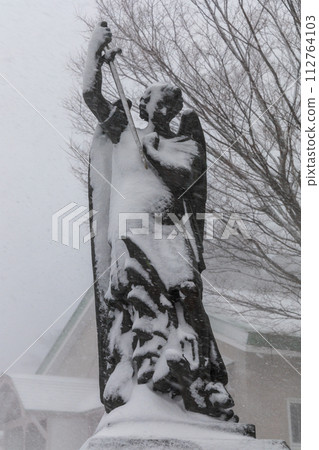 Archangel Michael statue standing in a snowstorm Archangel Michael statue standing in a snowstorm 112764103