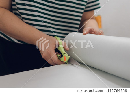 girl seamstress cuts fabric with scissors girl seamstress cuts fabric with scissors 112764538