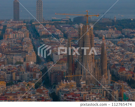 Aerial view of Barcelona City Skyline and Sagrada Familia Cathedral at sunset. Residential famous urban grid of Catalonia. Beautiful panorama of Barcelona. 112765474