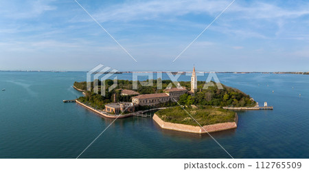 Aerial view of the plagued ghost island of Poveglia in the Venetian lagoon, opposite Malamocco along the Canal Orfano near Venice, Italy. 112765509
