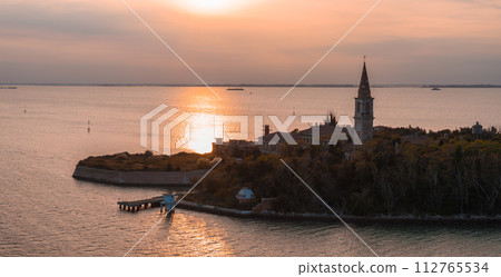 Aerial view of the plagued ghost island of Poveglia in the Venetian lagoon, opposite Malamocco along the Canal Orfano near Venice, Italy. Aerial view of the plagued ghost island of Poveglia in the Venetian lagoon, opposite Malamocco along the Canal Orfano near Venice, Italy. 112765534
