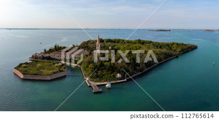 Aerial view of the plagued ghost island of Poveglia in the Venetian lagoon, opposite Malamocco along the Canal Orfano near Venice, Italy. Aerial view of the plagued ghost island of Poveglia in the Venetian lagoon, opposite Malamocco along the Canal Orfano near Venice, Italy. 112765614