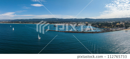 Beautiful aerial view of the Monterey town in California with many yachts docked by the pier. Beautiful aerial view of the Monterey town in California with many yachts docked by the pier. 112765733