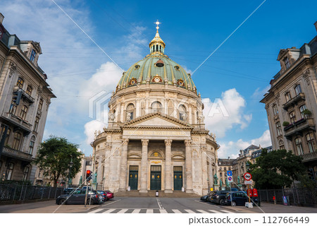 Copenhagen's Frederik's Church, The Marble Church, has a rococo style and a green copper dome with a gold orb and cross. Its grand front showcases Corinthian columns under a striking sky. Copenhagen's Frederik's Church, The Marble Church, has a rococo style and a green copper dome with a gold orb and cross. Its grand front showcases Corinthian columns under a striking sky. 112766449
