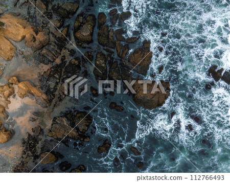 Aerial view of the huge Pacific ocean waves hitting the shore of California. Aerial view of the huge Pacific ocean waves hitting the shore of California. 112766493