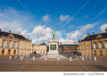 A serene, empty public square in Copenhagen, featuring a central equestrian statue, classical European buildings with mansard roofs, and ongoing restoration work. A serene, empty public square in Copenhagen, featuring a central equestrian statue, classical European buildings with mansard roofs, and ongoing restoration work. 112766501