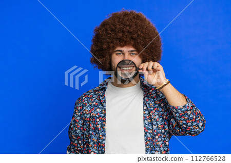 Happy smiling Caucasian man holding magnifier glass on teeth health care hygiene stomatology concept Happy smiling Caucasian man holding magnifier glass on teeth health care hygiene stomatology concept 112766528
