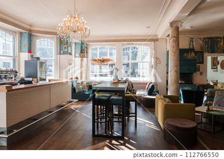 Luxurious Engelberg ski resort interior with moderntraditional decor, natural light, and a bar counter. Features hardwood floors, plush seating, and an elegant chandelier. Luxurious Engelberg ski resort interior with moderntraditional decor, natural light, and a bar counter. Features hardwood floors, plush seating, and an elegant chandelier. 112766550