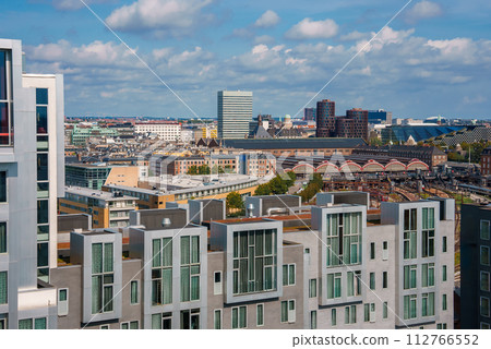 Modern cityscape, whitefronted buildings with big windows in the front, diverse architecture behind, under a semicloudy skyprobably Copenhagen. 112766552