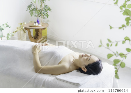 Middle-aged woman lying on bed at beauty salon 112766614