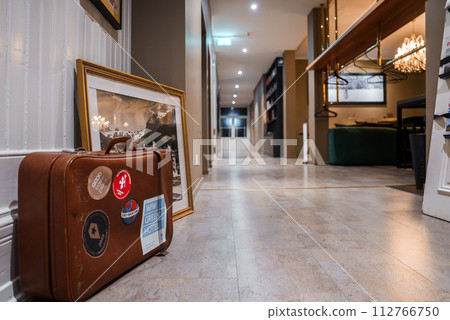 Luxurious hotel hallway in Engelberg with a vintage ski scene picture, a classic suitcase, and a modern chandelier, capturing the blend of history and contemporary elegance. Luxurious hotel hallway in Engelberg with a vintage ski scene picture, a classic suitcase, and a modern chandelier, capturing the blend of history and contemporary elegance. 112766750