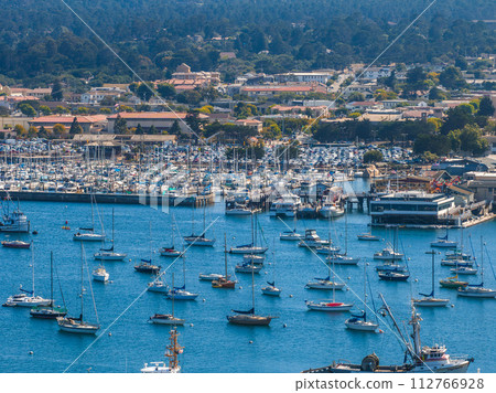 Beautiful aerial view of the Monterey town in California with many yachts docked by the pier. Beautiful aerial view of the Monterey town in California with many yachts docked by the pier. 112766928