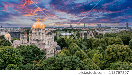 The Nativity of Christ Cathedral in Riga, Latvia. Byzantine-styled Orthodox cathedral, the largest in the Baltic region, with golden colored dome, polished gilded cupolas gleaming through the trees 112767207