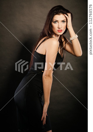 woman in sensual black dress on dark woman in sensual black dress on dark 112768576