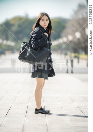 High school girl standing and looking at the camera and winter cityscape High school girl standing and looking at the camera and winter cityscape 112768831