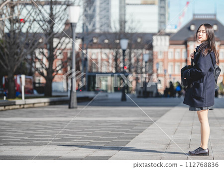 High school girl standing and looking at the camera and winter cityscape High school girl standing and looking at the camera and winter cityscape 112768836