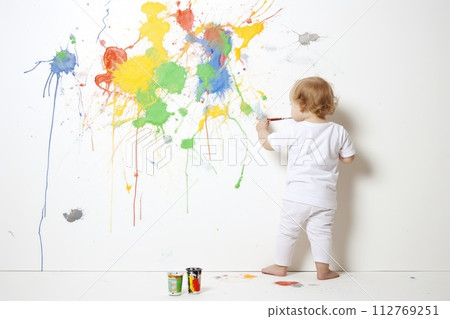 a baby is sitting at a table covered in paint a baby is sitting at a table covered in paint 112769251
