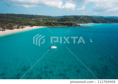 Boat floating on blue water at tropical island 112769409