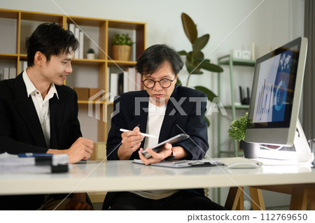 Business people using digital tablet and discussing over new business project at office Business people using digital tablet and discussing over new business project at office 112769650