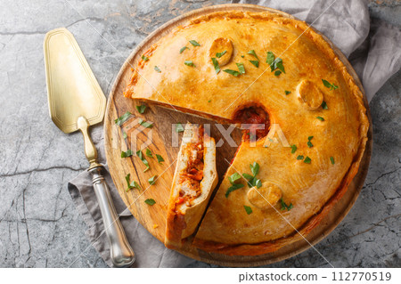 Empanada Gallega Traditional pie stuffed with tuna or meat and vegetables typical from Galicia, Spain closeup on the board. Horizontal top view 112770519