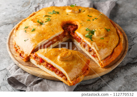 Galician Pie or Empanada Gallega stuffed with tuna or meat and vegetables closeup on the board. Horizontal 112770532