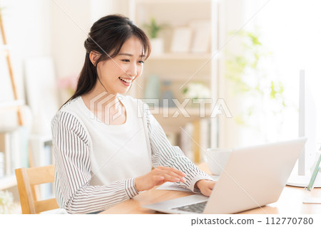 一名年輕女子在遠距辦公期間在客廳工作 112770780