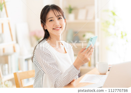 A young woman working from the living room during telework 112770786