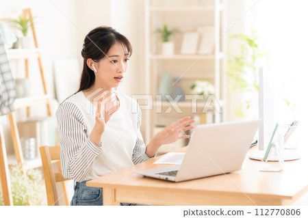A young woman working from the living room during telework A young woman working from the living room during telework 112770806