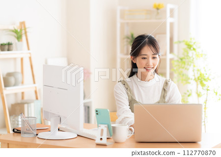 一名年輕女子在遠距辦公期間在客廳工作 112770870