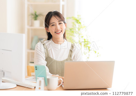 一名年輕女子在遠距辦公期間在客廳工作 112770877