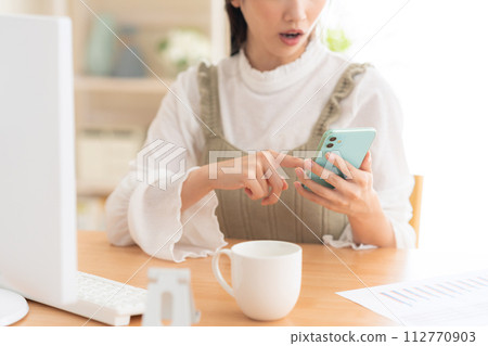 A young woman working from the living room during telework A young woman working from the living room during telework 112770903
