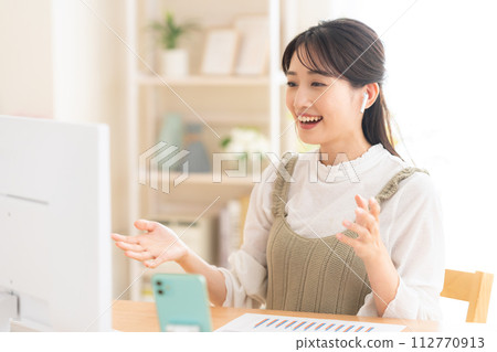 A young woman working from the living room during telework 112770913
