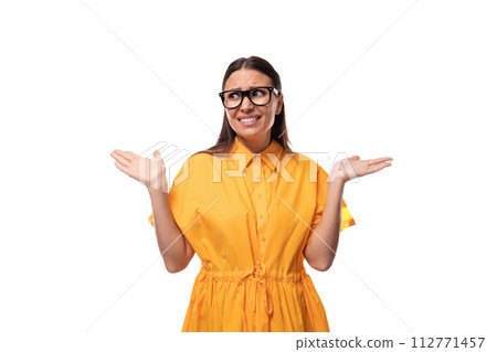 Caucasian young slim woman with black straight hair with glasses and in a yellow dress doubts on a Caucasian young slim woman with black straight hair with glasses and in a yellow dress doubts on a 112771457