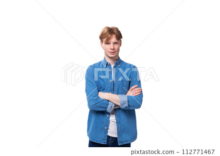 portrait of a young stylish european guy with golden hair dressed in a blue denim shirt on a portrait of a young stylish european guy with golden hair dressed in a blue denim shirt on a 112771467