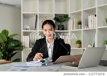 Young business woman asian or employee accounting bookkeeping documents checking financial data or marketing report working in office with laptop. Paperwork management 112771619