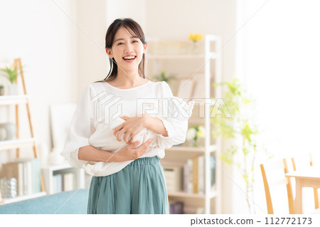 年輕的母親在客廳抱著她的孩子 112772173