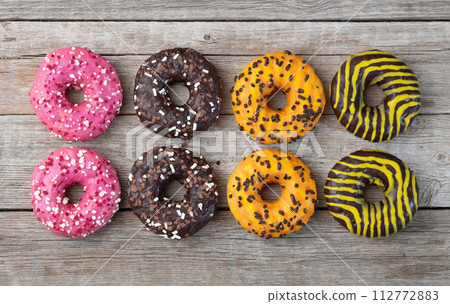Set of colorful donuts on wooden background Set of colorful donuts on wooden background 112772883