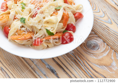 Italian pasta with shrimps , parmesan and tomatoes 112772900